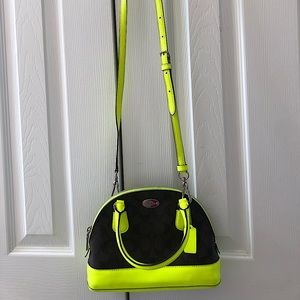 Dark brown Coach signature “C” pattern crossbody with bright green accents